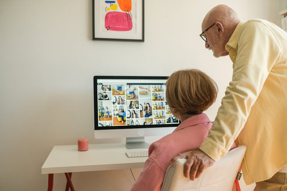 Senior couple enjoying browsing photos together at home on a desktop computer.